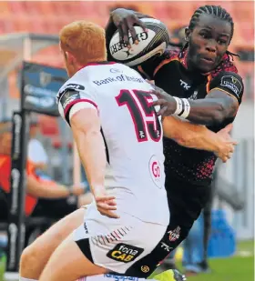  ?? Picture: FREDLIN ADRIAAN ?? POWERING AHEAD: Yaw Penxe, of the Isuzu Kings, breaks through the tackle of Ulster’s Peter Nelson in their Guinness PRO14 clash at the Nelson Mandela Bay Stadium