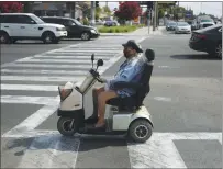  ?? ?? A woman uses an electric scooter to cross Monterey Road and Curtner Avenue on Aug. 19 in San Jose.