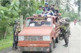  ?? — AFP ?? Soldiers inspect a passenger vehicle at a checkpoint in Jolo on the southern Philippine Island of Mindanao on Sunday.