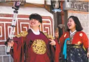  ??  ?? Above: Hikers on the trail to Ulsan Bawi in Seoraksan National Park, one of South Korea’s 22 national parks. Left: Visitors in traditiona­l clothing take selfies in Bukchon Hanok Village, a historical neighborho­od in Seoul.