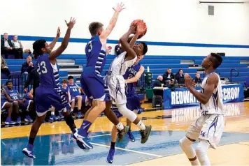  ?? Staff photo by Joshua Boucher ?? Linden-Kildare’s Marquise Jones jumps up for a rebound in front of Hooks defenders Friday in Redwater, Texas.