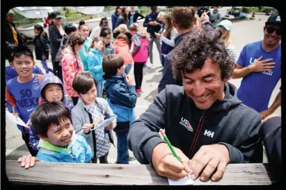  ?? PHOTO : WILL RICKETSON / US SAILING TEAM ?? Olympic Nacra 17 sailor Bora Gulari signs autographs at the US Sailing Team’s new training base on San Francisco Bay.