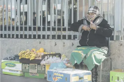  ?? Picture: Yeshiel Panchia ?? WRAPPED UP. Shelina Chabalala braces against the cold as she sells her wares on Main Reef Road in the CBD of Johannesbu­rg yesterday as the city was hit by a strong cold front.