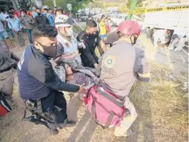  ?? AP ?? An injured migrant woman is moved by rescue personnel Thursday from the site of an accident near Tuxtla Gutierrez, Chiapas state, Mexico. Mexican authoritie­s say at least 55 were killed.