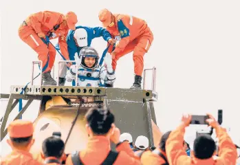  ?? GETTY-AFP ?? Back on Earth: China’s Ye Guangfu, one of three astronauts on the Shenzhou 13 capsule, is helped out of the craft Saturday. The trio, who stayed six months aboard their country’s newest orbital space station, landed in the Gobi desert. During the mission, Wang Yaping carried out the first spacewalk by a Chinese woman. Zhai Zhigang rounded out the crew.