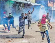  ?? AP ?? Protesters run for cover as security forces fire pellets and teargas shells after they were stopped from taking part in the funeral procession of slain militant Mussavir Wani in Pulwama district.