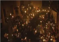  ?? ARIEL SCHALIT — THE ASSOCIATED PRESS ?? Christian pilgrims hold candles as they gather during the ceremony of the Holy Fire in the Old City of Jerusalem on May 1, 2021.