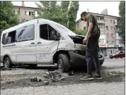  ?? ALEXEI ALEXANDROV / AP ?? A man inspects a car damaged during shelling in Donetsk, in territory under the government of the Donetsk People’s Republic, eastern Ukraine on Wednesday.
