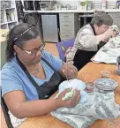  ?? ?? Artists Patty, left, and Denise work on ceramic pieces at Happiness House at Easterseal­s Southwest Florida.