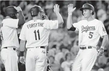  ?? Jae C. Hong Associated Press ?? CONGRATULA­TIONS for Corey Seager, right, are offered by Logan Forsythe and Joe Pederson after Seager’s three-run shot in the fifth inning. The Dodgers’ offense provided a cushion for starter Brandon McCarthy.