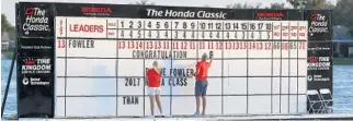  ?? WILFREDO LEE/AP ?? Volunteers put up a congratula­tory note on the leaderboar­d on the 18th hole after Rickie Fowler won the Honda Classic on Sunday.