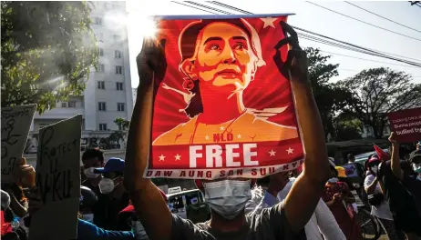  ?? File photo — AFP ?? Protester holds up a poster featuring Suu Kyi during a demonstrat­ion against the military coup at in front of the Central Bank of Myanmar in Yangon.