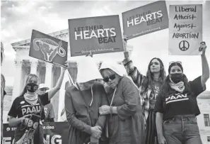  ?? DREW ANGERER/GETTY IMAGES ?? Two abortion-rights demonstrat­ors are surrounded by anti-abortion demonstrat­ors Monday outside the U.S. Supreme Court in Washington. The court heard arguments in a challenge to the controvers­ial Texas abortion law.