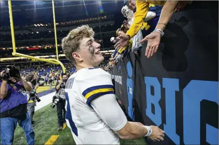  ?? AJ MAST/AP ?? Michigan quarterbac­k J.J. Mccarthy celebrates with fans after the Big Ten championsh­ip win over Iowa on Dec. 2. The Wolverines are considered slight betting favorites over Alabama in today’s Rose Bowl game, but there are a lot of skeptics, too.