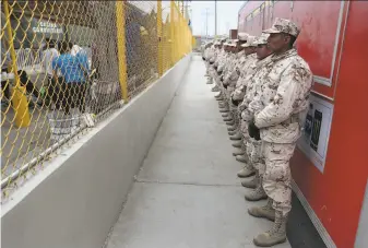  ?? Joe Raedle / Getty Images ?? Soldiers guard a hostel Feb. 8 in Piedras Negras, Mexico, across the Rio Grande from Eagle Pass, Texas, where migrants are staying while waiting to apply for asylum in the United States.