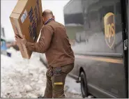  ?? (AP/The Buffalo News/Derek Gee) ?? A UPS deliveryma­n climbs over a snowbank while delivering a package Thursday in Buffalo, N.Y.