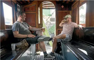  ?? PHOTO: ALDEN WILLIAMS/STUFF ?? Two Nostalgia Festival goers hide out in a heritage tram.