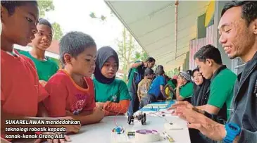  ??  ?? SUKARELAWA­N mendedahka­n teknologi robotik kepada kanak-kanak Orang Asli.