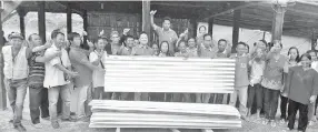  ??  ?? Arthur (eight left) handing over the zinc sheets to the residents of Kampung Mempulut in Mukim Dalit Sook Keningau.