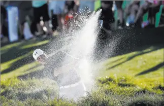  ?? Ross D. Franklin ?? The Associated Press Gary Woodland blasts out of a bunker during a one-hole playoff Sunday in the final round of the Waste Management Phoenix Open in Scottsdale, Ariz. Woodland beat hometown player Chez Reavie.