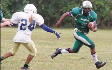  ??  ?? ABOVE: Georgia School for the Deaf’s Zykevious Walton (right) eludes a Carolinas player during Saturday’s game in Cave Spring. Walton ran for 289 yards and five touchdowns in the win.