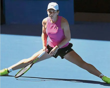  ?? — AFP ?? Full stretch: Simona Halep of Romania slides to a halt during a practice session in Melbourne on Thursday ahead of the Australian Open tennis tournament which starts tomorrow.