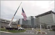  ?? H John Voorhees III / Hearst Connecticu­t Media ?? Kyle DeLucia, owner of K&J Tree Service, and his crew set up a crane at the entrance to Danbury Hospital with a 50-foot American flag and a giant thank you sign to show their appreciati­on to the hospital staff serving the community during the pandemic.