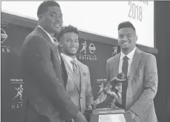  ?? RALPH RUSSO/AP ?? Heisman Trophy finalists, from left, Dwayne Haskins, Kyler Murray and Tua Tagovailoa pose with the award Friday at the New York Stock Exchange.