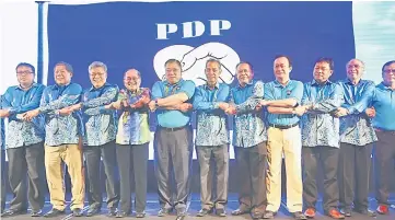  ?? — Photo by Muhammad Rais Sanusi ?? Tiong (fifth left) and Uggah (fourth left) joined by the other PDP leaders in a symbolic gesture after the launch of the new logo, which depicts two hands engaged in a handshake and shaped like a heart.