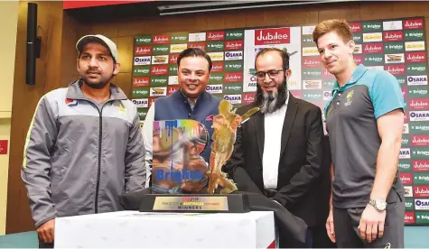  ?? Virendra Saklani/Gulf News ?? Pakistan captain Sarfraz Ahmad (left) and Australia captain Tim Paine (right) with sponsors Kamran Ahmad and Syed Usman Qaiser unveiling the trophy on the eve of the first Pakistan-Australia Test at the Dubai Internatio­nal Cricket Stadium yesterday.