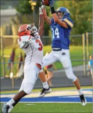  ?? SAM STEWART - DIGITAL FIRST MEDIA ?? Downingtow­n West’s Dan Byrnes (14) hauls in a 31yard pass in front of Perkiomen Valley’s Matt Ford-Bey Saturday.