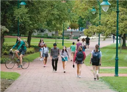  ?? DARRON CUMMINGS/AP 2021 ?? Students make their way to and from classes on the campus of Indiana University in Bloomingto­n.