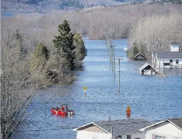  ?? ANDREW VAUGHAN / THE CANADIAN PRESS ?? A Coast Guard vessel heads across a flooded area at Darlings Island, N.B., last week. Ottawa is stepping into help residents clean up in the flood-ravaged province.