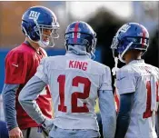  ?? HOWARD SIMMONS / TNS ?? Eli Manning (left) gets reacquaint­ed with his receivers at Wednesday’s practice after being reinstated as the Giants’ starting quarterbac­k.