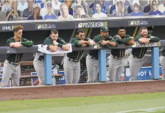  ?? Harry How / Getty Images ?? The A’s watch at Dodger Stadium as the Astros finish battering Oakland pitchers in the ALDS. A’s starters were stingier at home, but the pandemic led to postseason games at neutral sites.