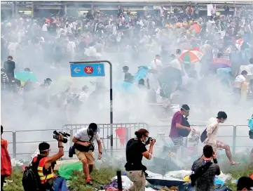  ??  ?? File photo shows people dispersing after police fired tear gas upon pro-democracy demonstrat­ors near the Hong Kong government headquarte­rs.