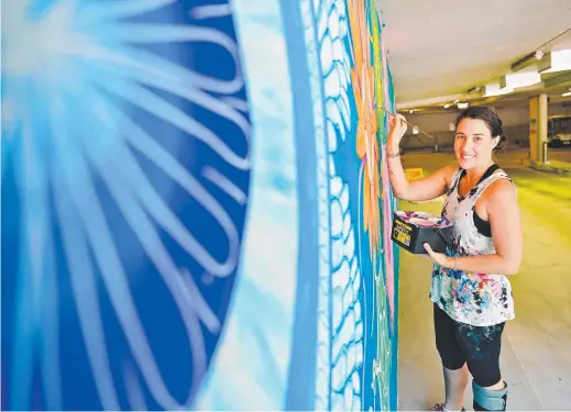  ??  ?? Artist Polly Johnstone was kept busy last year painting a new mural at the Darwin Waterfront car park