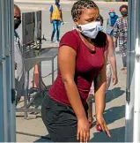  ?? AP ?? A woman wearing a face mask to protect against coronaviru­s, walks through a disinfecti­ng spray booths aimed to combat the spread of Covid-19 at Alexandra township in Johannesbu­rg, South Africa.