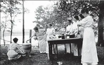  ?? University of Arkansas Division of Agricultur­e Cooperativ­e Extension Service ?? An early 20th-century Home Demonstrat­ion Club learns about canning fresh produce from members’ gardens.