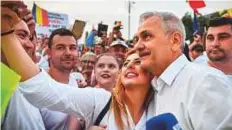  ?? AFP ?? The leader of Romania’s Social Democratic Party (PSD) Liviu Dragnea poses for a selfie with a supporter during a demonstrat­ion against anti-graft prosecutor­s in Bucharest.