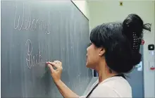  ?? LANCE ANDERSON TORSTAR ?? Teacher Popo Dass writes welcoming message for students inside one of the newly renovated classrooms at the Children’s Montessori School.