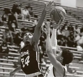  ?? Kin Man Hui / Staff photograph­er ?? Clark's Jason Osonma (24) attempts to block a shot against Johnson's L.J. Brown during their 28-6A game Friday night at Littleton Gym.