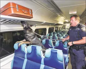  ?? Metropolit­an Transit Authority / Contribute­d Photo ?? Above, MTA Police Capt. John Kerwick and his partner, Hero, a 4-year-old German shepherd, takes part in training on a rail car at Grand Central Terminal in New York City. Below, Kerwick and Hero check luggage in Grand Central.
