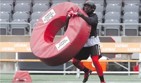  ?? TONY CALDWELL ?? Ottawa Redblacks Chris Ackie works with some tackling equipment at TD Place field Thursday. Ackie, who can play linebacker or defensive back, was just traded to Ottawa from Montreal.