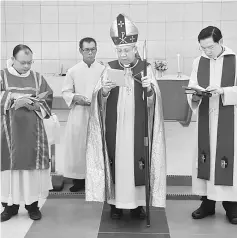  ??  ?? Aries Sumping (centre), flanked by Sub-Deacon Western Ranggin (left) and Revd Joshua Jo (right), performing prayers during the confirmati­on service.