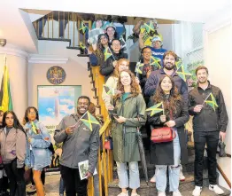  ?? PHOTOS BY DERRICK SCOTT ?? A group of visitors to Passport DC at the Embassy of Jamaica in Washington, DC, waves Jamaican flags as they pause for a photograph with deputy chief of mission at the Embassy, Lishann Salmon (centre).