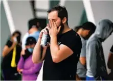  ?? SUSAN STOCKER/ SOUTH FLORIDA SUN SENTINEL ?? A man speaks on his cellphone near the makeshift family reunificat­ion center at 9301 Collins Ave. in Surfside on Thursday. Authoritie­s said the death toll was likely to rise.