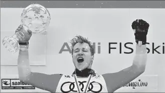  ?? AFP ?? Marco Odermatt, the overall season winner of the men’s Alpine Skiing World Cup, celebrates with his crystal globe trophy on the podium on Sunday.