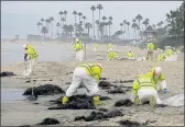  ?? RINGO H.W. CHIU — ASSOCIATED PRESS ?? Workers in protective suits clean the contaminat­ed beach in Corona Del Mar after an oil spill in Newport Beach on Oct. 7.