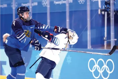  ?? Frank Franklin II/The Associated Press ?? ■ Monique Lamoureux-Morando (7) of the United States takes a punch from Rosa Lindstedt (4), of Finland, of the women's hockey game Sunday at the 2018 Winter Olympics in Gangneung, South Korea.
during the second period of the preliminar­y round